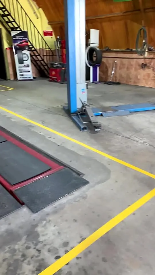 Interior da oficina da Bravo Pneus, com elevador e placa de alinhamento